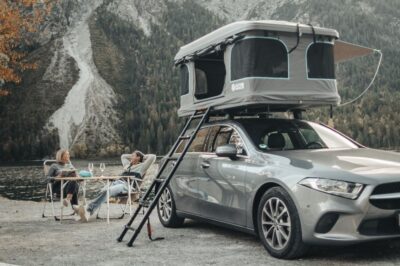 Auto mit aufgestelltem Dachzelt am Seeufer in Bretzfeld bei Heilbronn – Dachzelt mieten oder kaufen bei Weber Camping Werkstatt Naturbummler, entspanntes Camping in der Natur